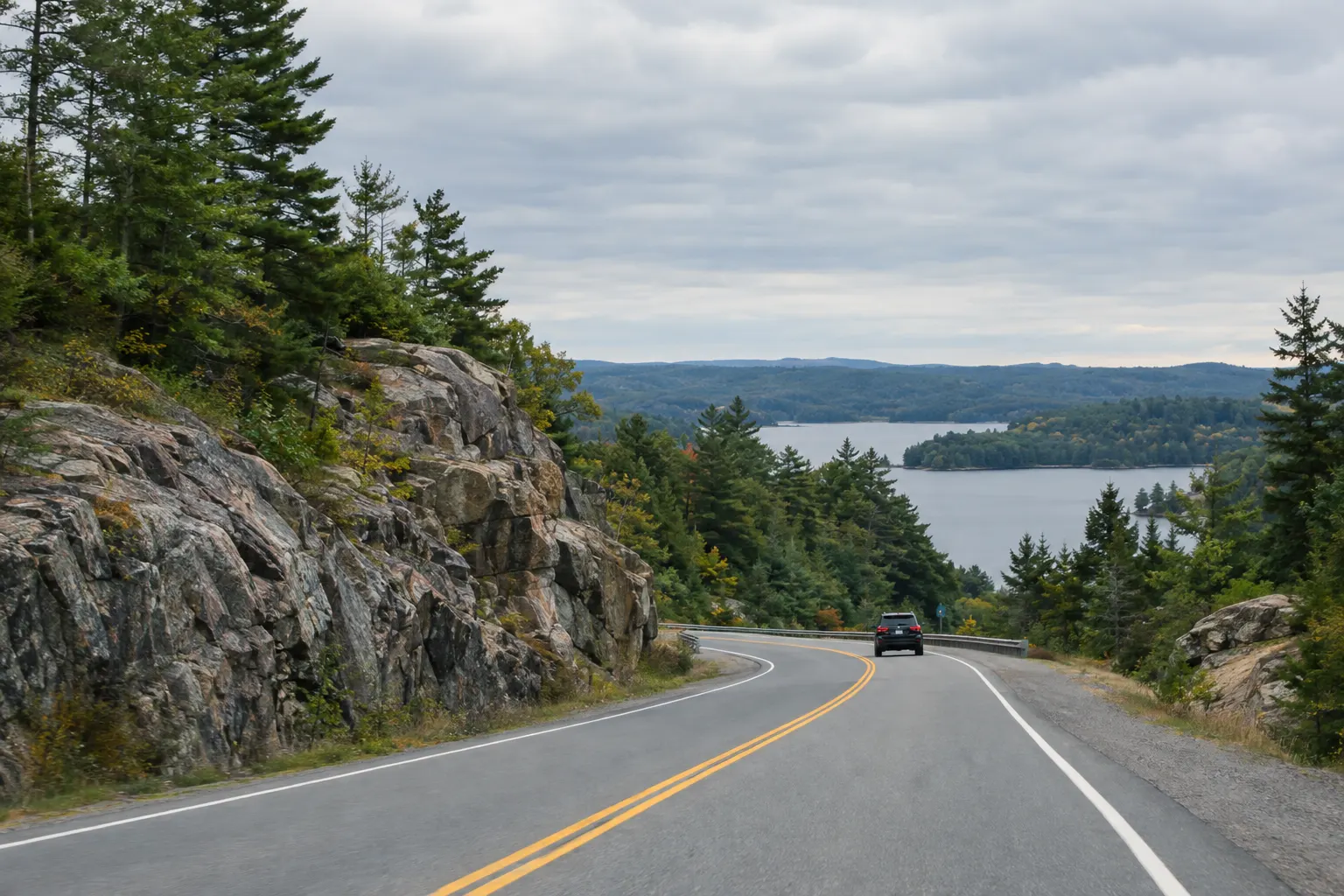 A highway through granite rock cuts and pine forest in Muskoka